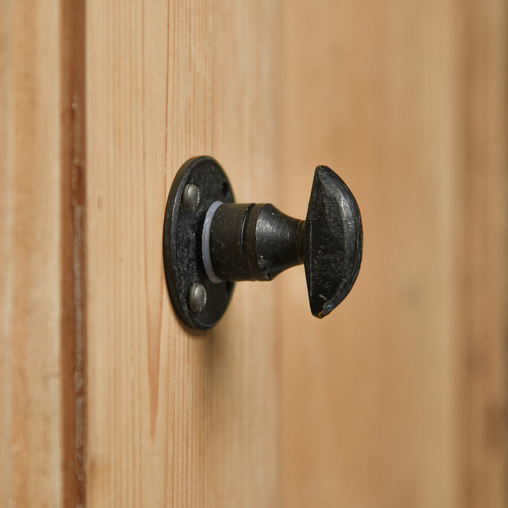 Black thumbturn for a bathroom door on a pine door