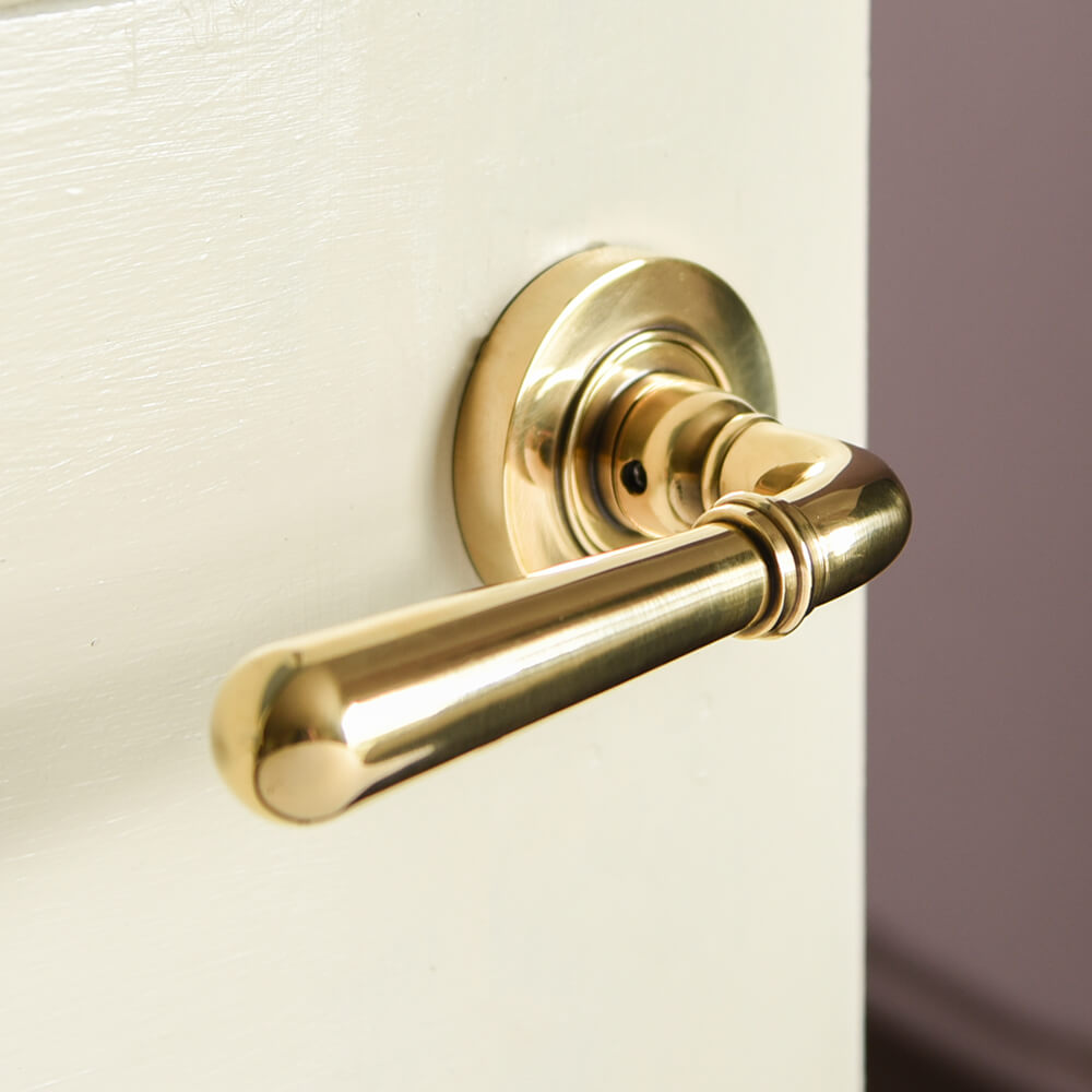 Polished Antique Brass Newbury Lever Door Handles on Concealed Rose showing close up of the smooth lever