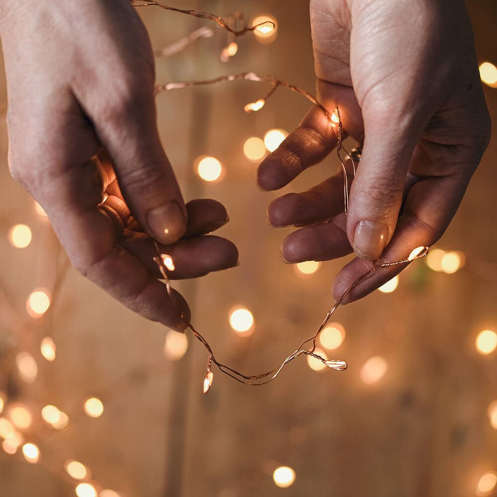 Copper wire led lights being held between two hands