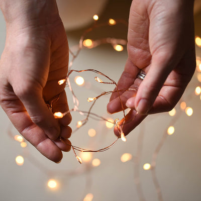 Copper wire led lights being held between two hands