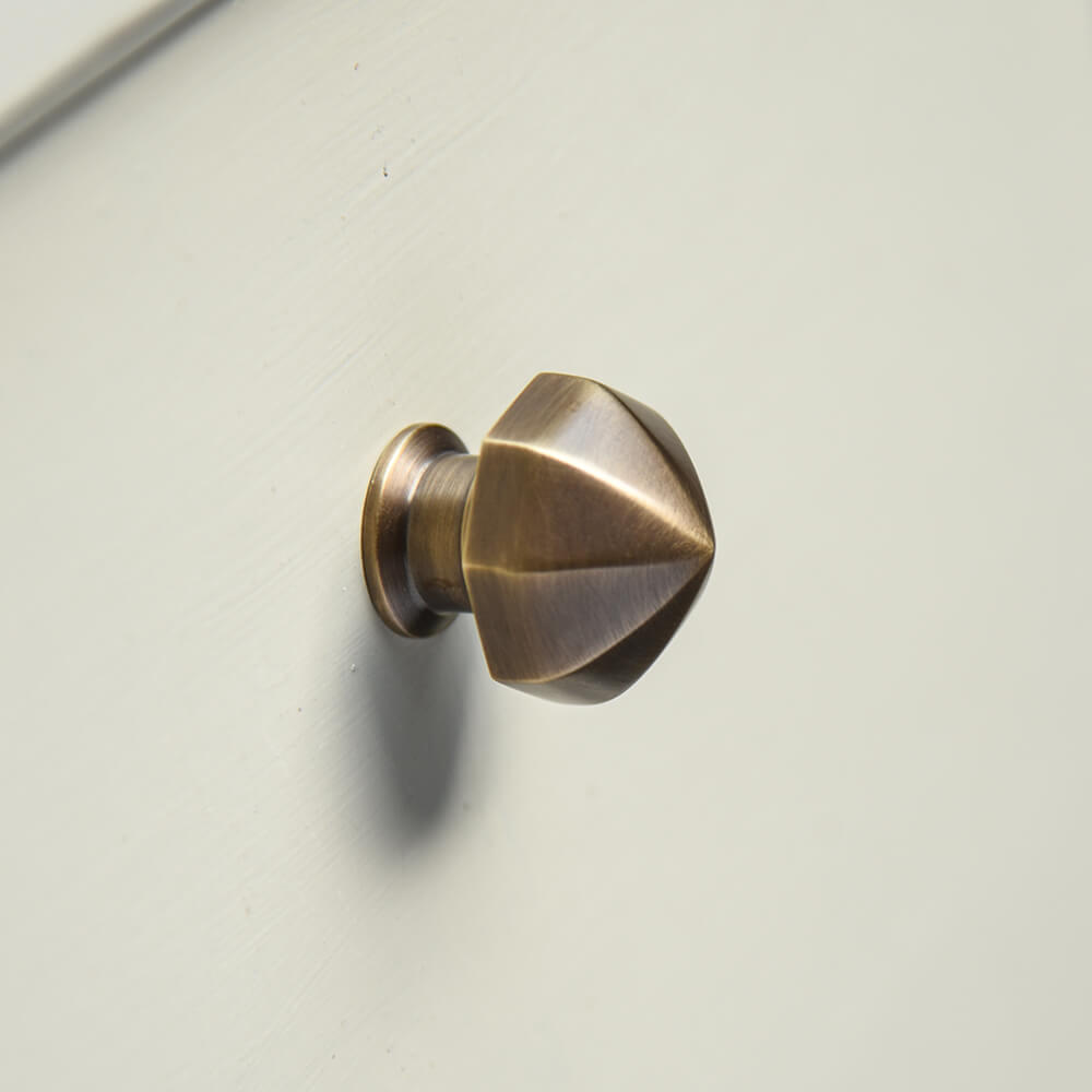 Pointy octagonal cupboard knob with a light antique brass finish