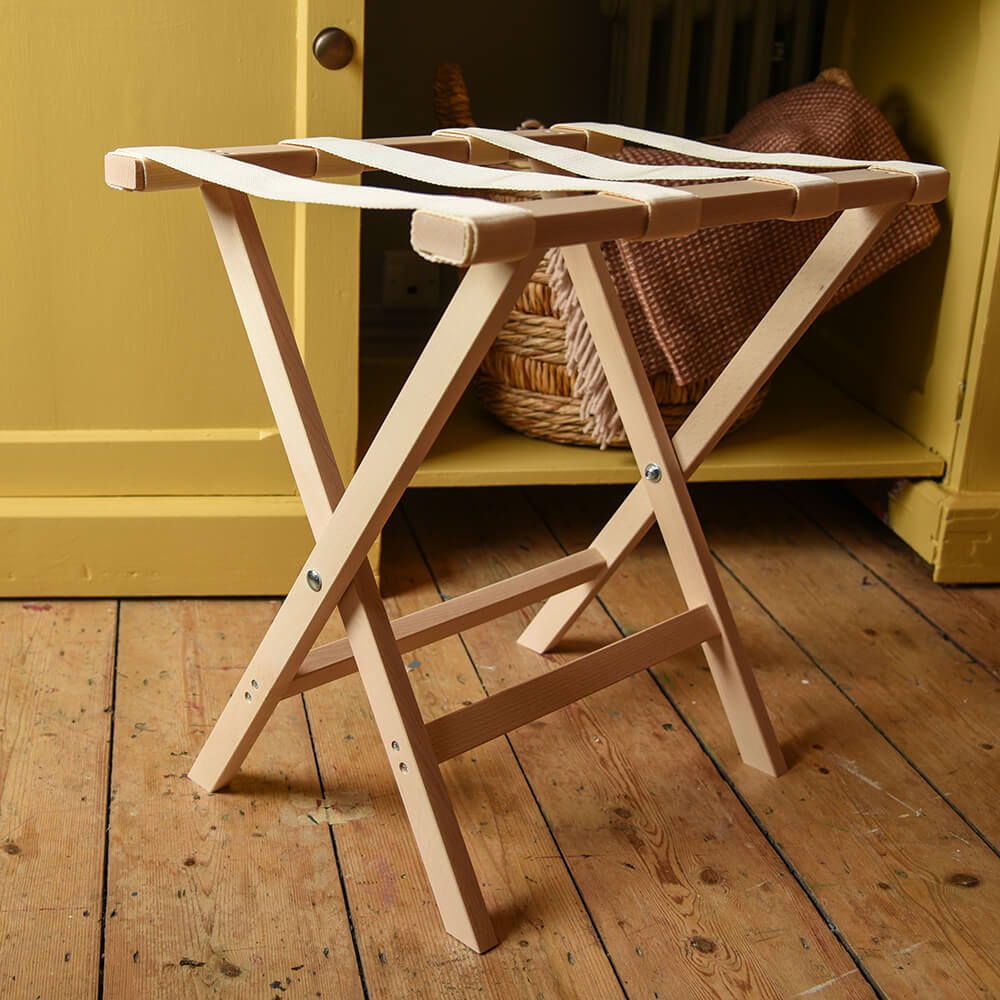 Luggage rack in front of yellow cupboard