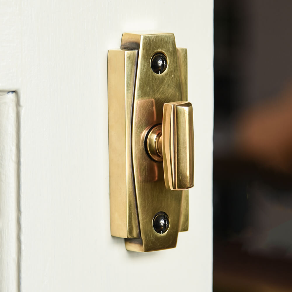 Art Deco styled thumbturn latch in brass on a bathroom door