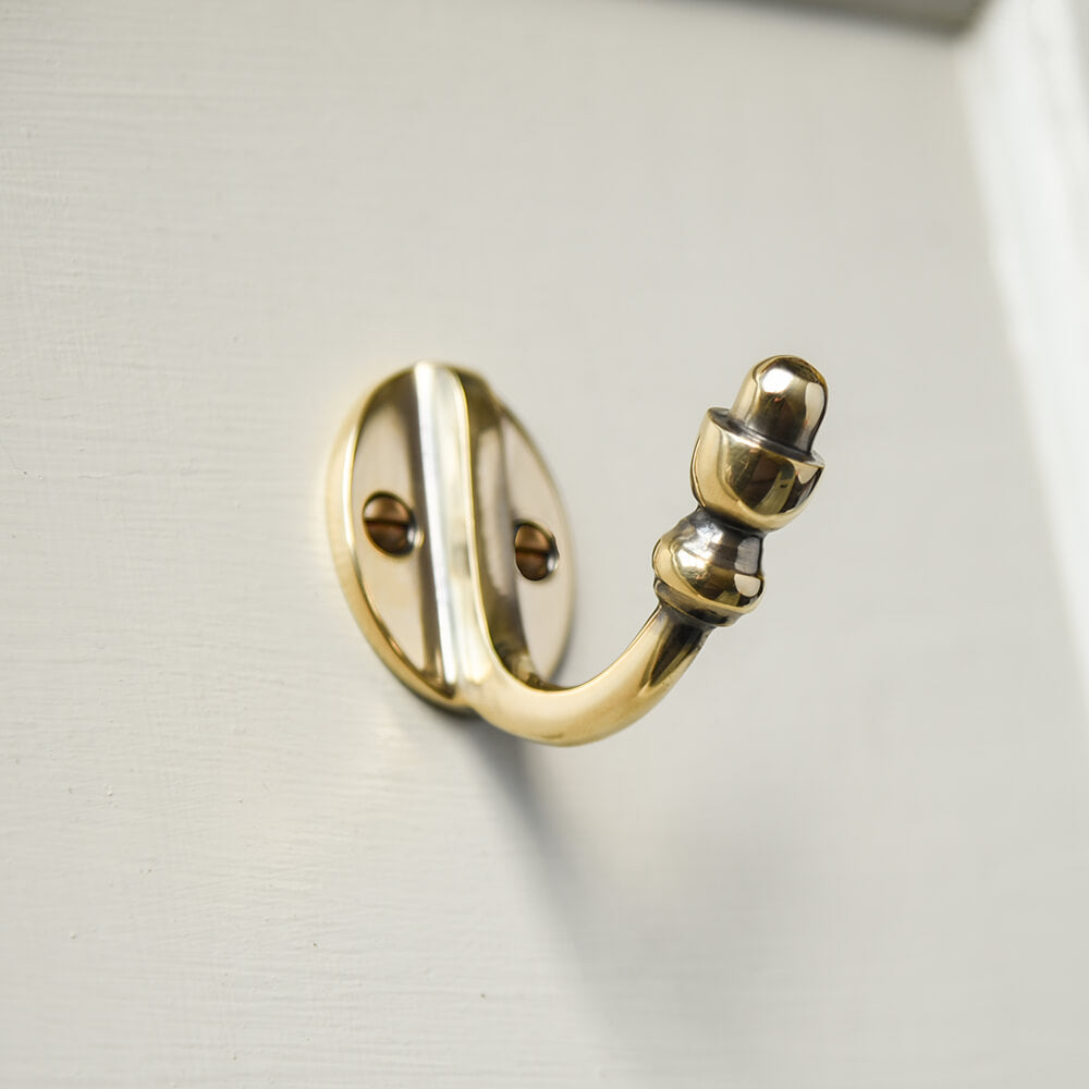 Brass single hook with acorn detail to the finial