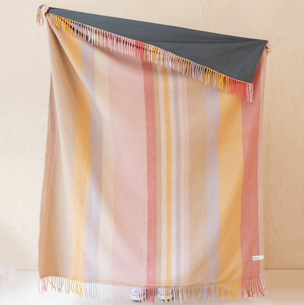 Recycled-Wool-Picnic-Blanket-Coral-Stripe-being-held-aloft