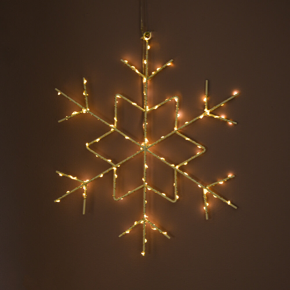 Snowflake light seen illuminated on a dark wall