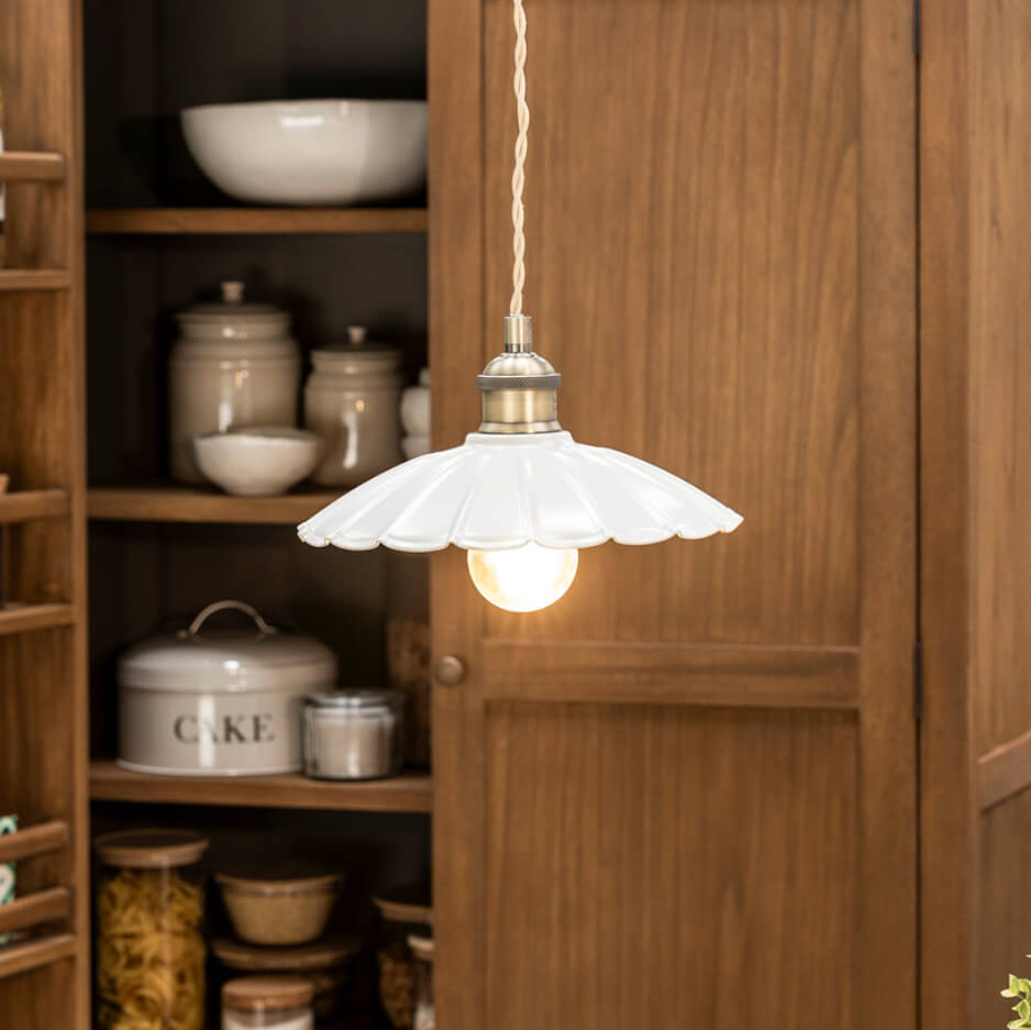 White frilly edged light hung in front of kitchen cabinet