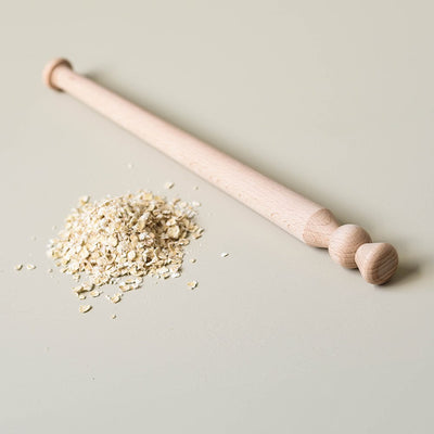 solid oak porridge stirrer with a pile of oats