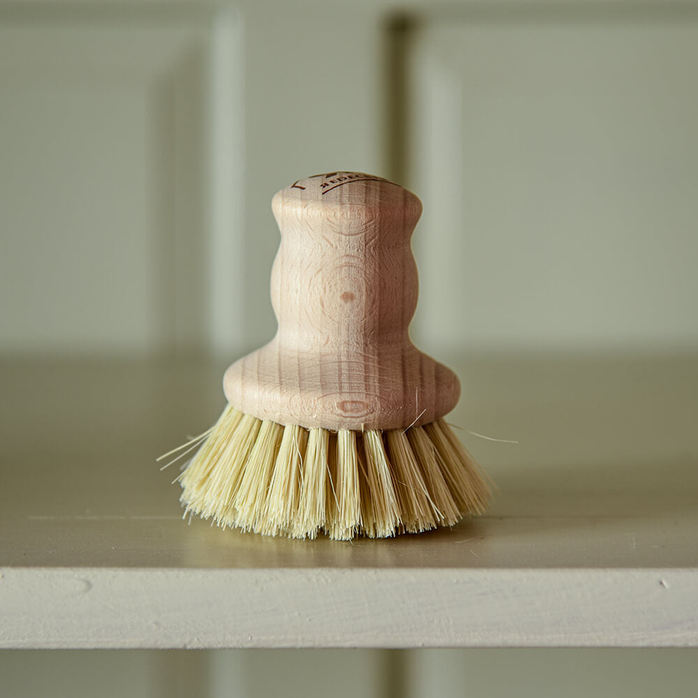 Wooden pot brush on shelf